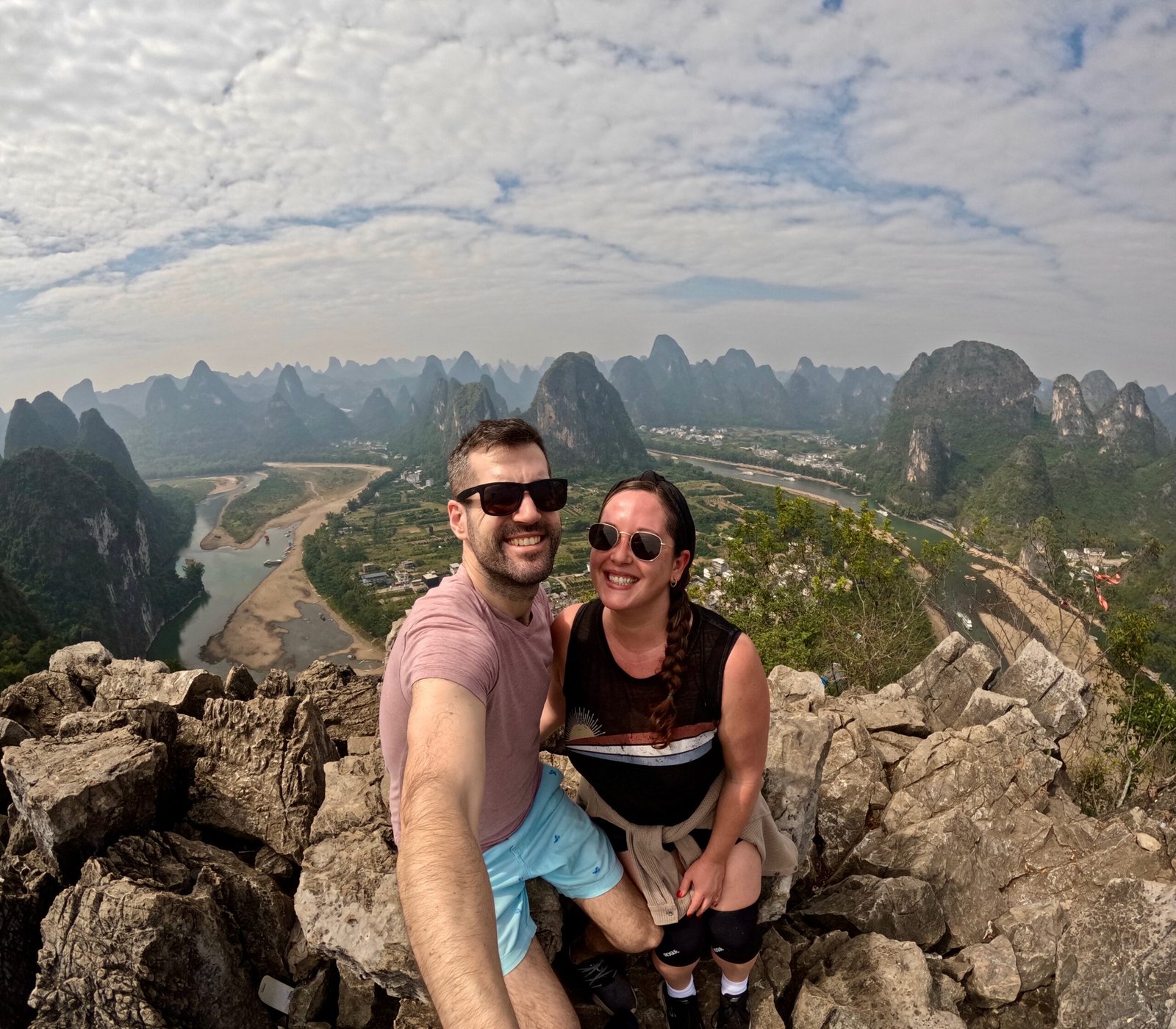Couple on mountain overlooking landscape.