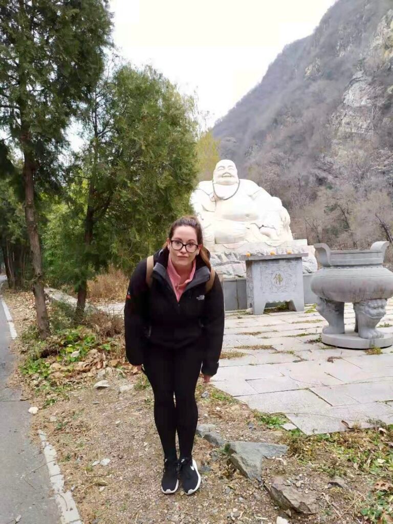 Large white Buddha statue in the mountains near Great Wall of China.